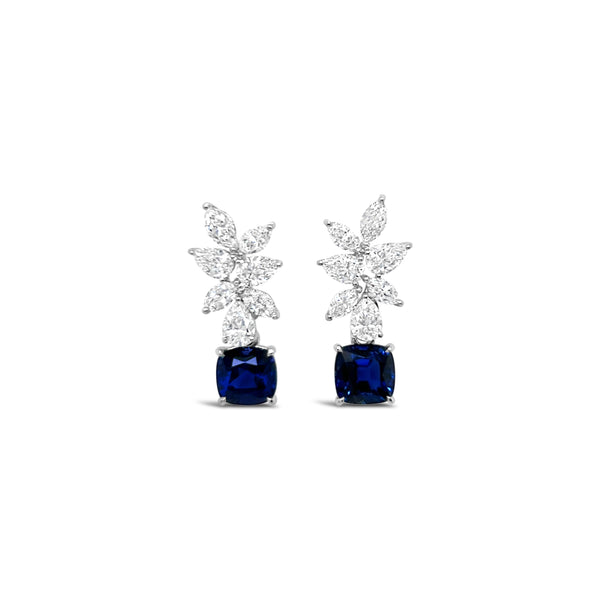Pair of earrings with blue gemstones and diamond-like elements on a white background